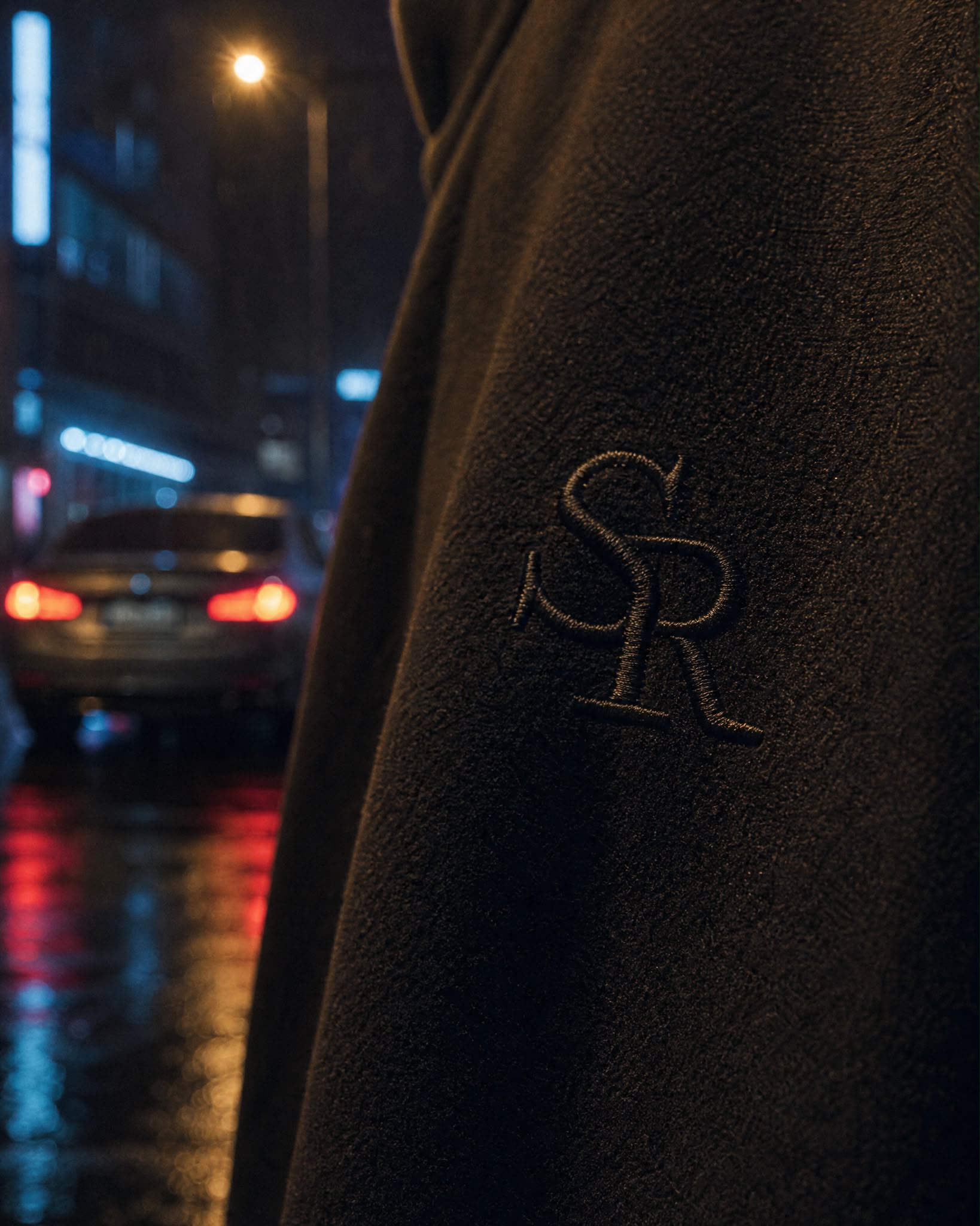 Gros plan sur le monogramme SR brodé ton sur ton