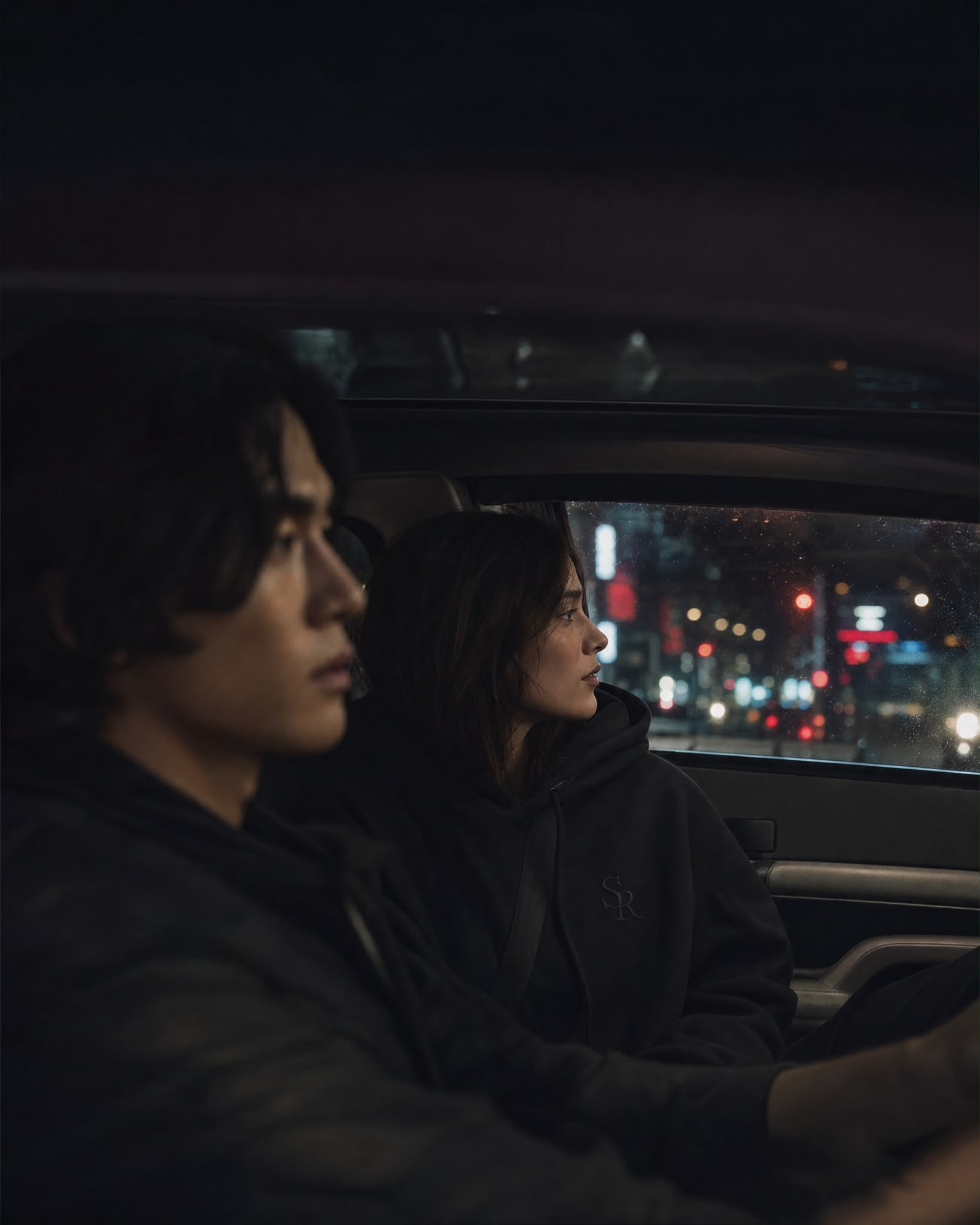 Couple à l'arrière d'une voiture, lumières de la ville